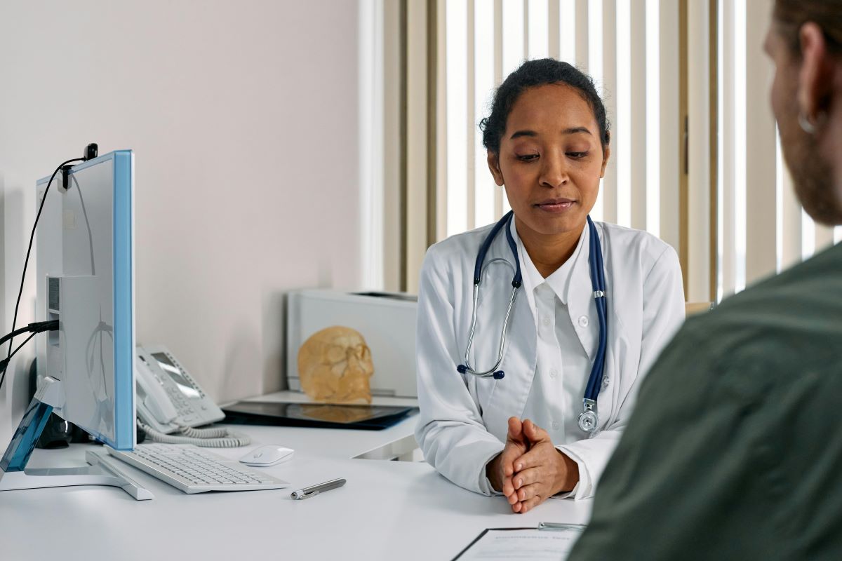 doctor in white coat behind desk